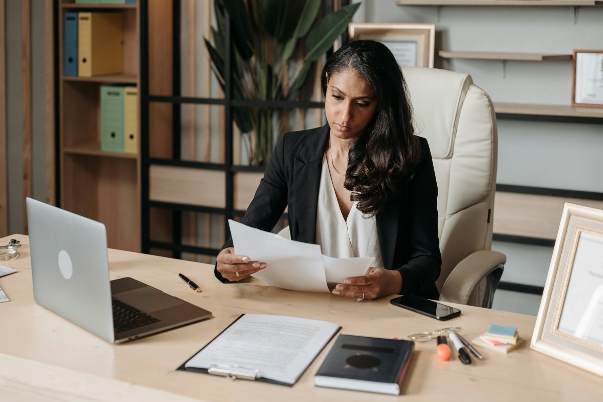Female professional reviewing documents at her desk
