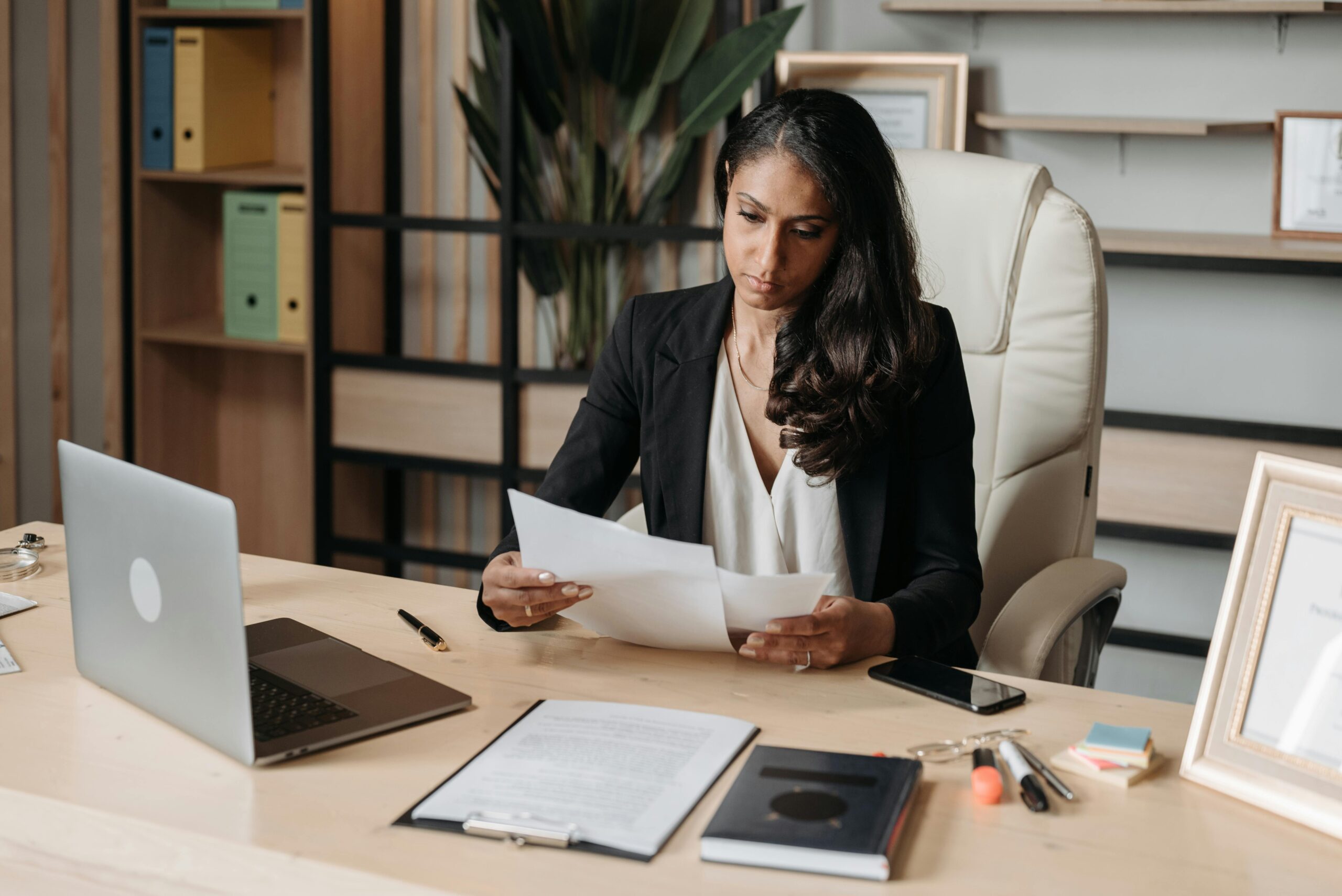 Young, professional woman at her desk reading paperwork