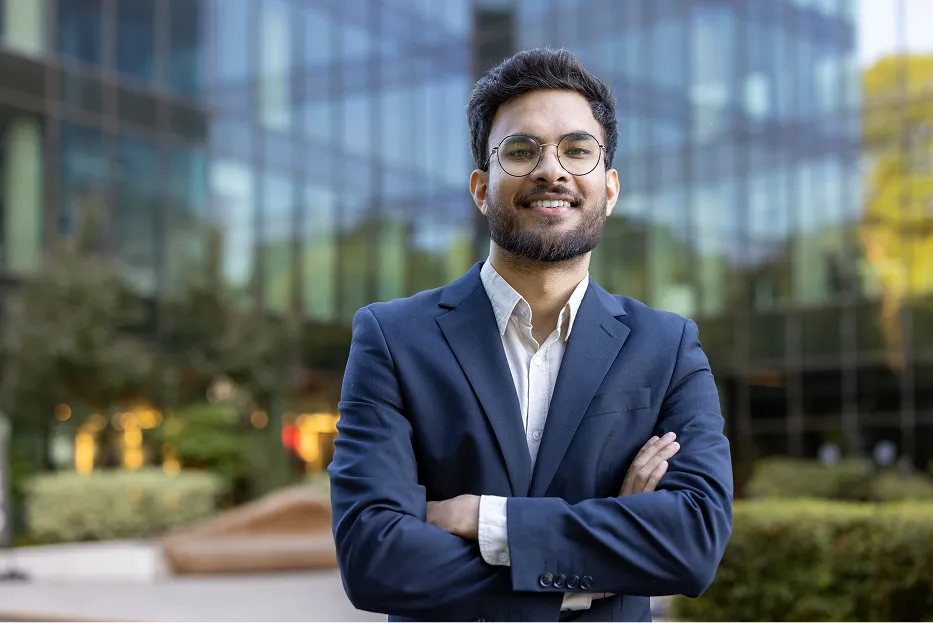 Young male professional with glasses standing infront of office building